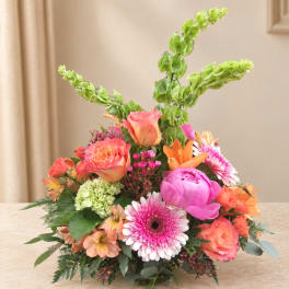 Colorful mixed bouquet with roses, lilies, and gerbera daisies in a low arrangement