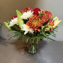 Mixed bouquet of chrysanthemums and lilies in a glass vase