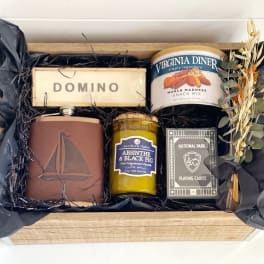 Gift box with snacks, candle, playing cards, and dried flowers