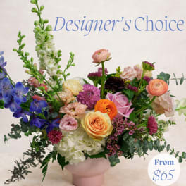 Mixed bouquet in a pink vase with blue, pink, orange, and white flowers