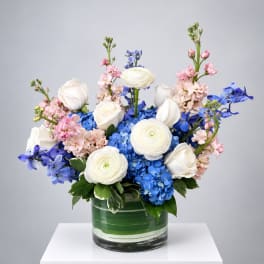 Blue and white floral arrangement in a glass vase