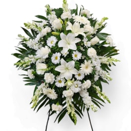 White funeral spray with lilies, daisies, and carnations