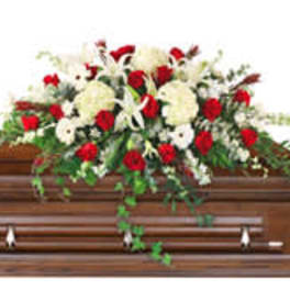 Red and white floral spray on a wooden casket