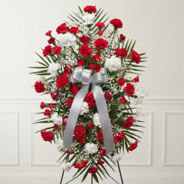 Standing wreath of red and white carnations with a silver ribbon