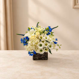 White and blue flower arrangement in a square basket