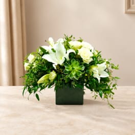White lilies and roses in a dark square vase