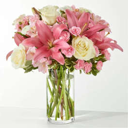 Pink lilies and cream roses in a clear glass vase