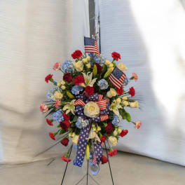 Standing floral spray with red, white, and blue flowers and American flags
