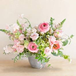 Pink and white floral arrangement in a gray vase