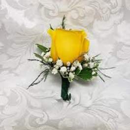 Yellow rose boutonniere with white filler flowers on a white background