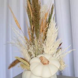 White pumpkin vase filled with dried grasses and wheat
