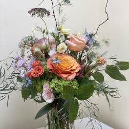 Mixed bouquet of peach and pink roses in a glass vase