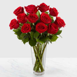 Red roses arranged in a clear glass vase