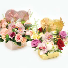 Mixed bouquet in a gold box on a wooden table