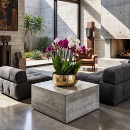 Orchid arrangement in a gold bowl on a concrete table