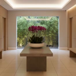 Purple orchids in a white bowl on a table in a modern room