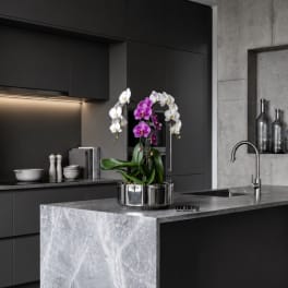 Potted orchid arrangement with white and purple blooms in a metal container