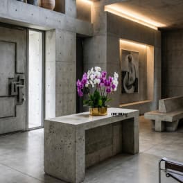 Purple and white orchids in a gold pot on a concrete table