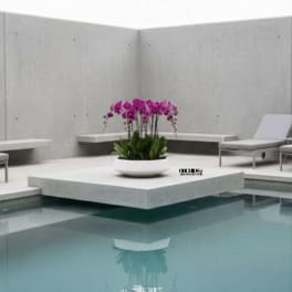 Purple orchids in a white bowl on a modern patio by a pool
