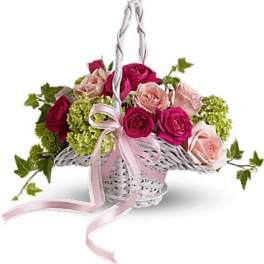 Basket of pink and red roses with green hydrangeas and a pink ribbon