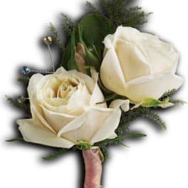 White rose boutonniere with greenery and a pink wrapped stem