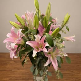 Pink lilies arranged in a clear glass vase