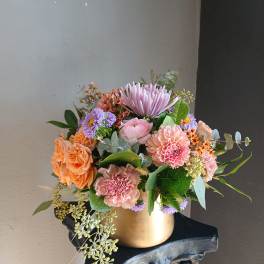 Pastel mixed flower arrangement in a gold vase