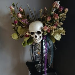 Skull centerpiece with pink roses and ribbons in a clear vase