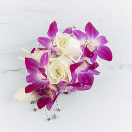 Wrist corsage with white roses and bright pink orchids and rhinestone accents