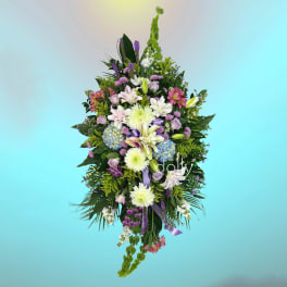 Tall mixed floral spray with lilies, roses, and hydrangeas in pink, white, and purple