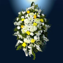 White and yellow floral spray with lilies and roses on a dark blue background