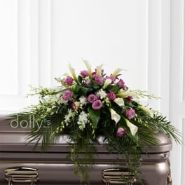 Pink roses and white calla lilies arranged on a casket