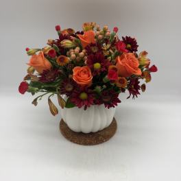 Orange roses and burgundy daisies in a white pumpkin vase