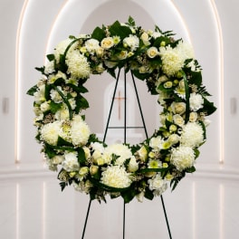 White floral wreath on a stand in a church interior
