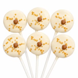 Six white cake pops with amber sprinkles on sticks
