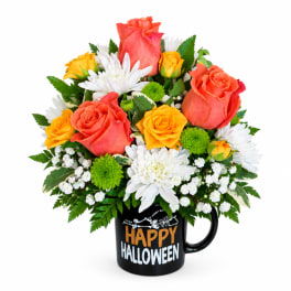 Bouquet of orange and yellow roses with white daisies in a Halloween mug
