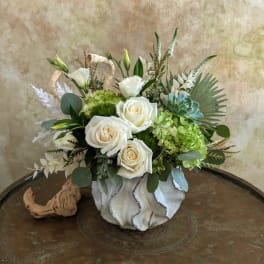 White roses and green hydrangeas in a ceramic vase