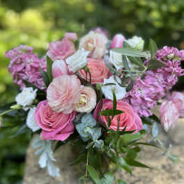 Pink and white bouquet of roses and ranunculus with greenery