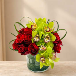 Red roses and green orchids in a glass vase