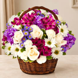 Basket of white roses, daisies, and purple flowers