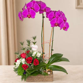Orchid and rose arrangement in a wooden box with a heart pick