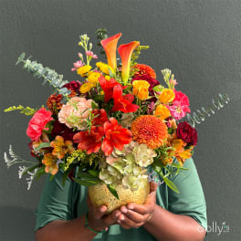 Colorful mixed bouquet in a speckled vase held by a person