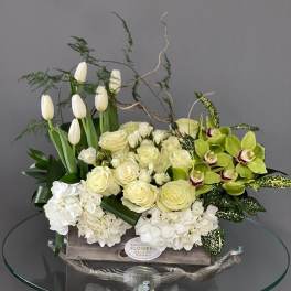 White tulips, roses, hydrangeas, and green orchids in a wooden box