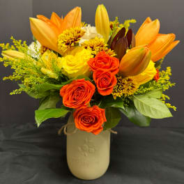 Orange and yellow bouquet in a beige vase