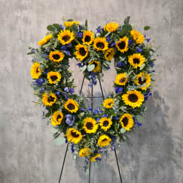 Heart-shaped sunflower wreath on a stand with blue flowers