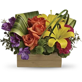 Colorful bouquet with roses and lilies in a wooden box