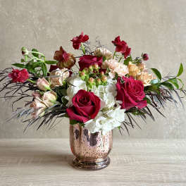 Mixed bouquet of roses and hydrangeas in a metallic vase