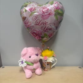 Pink heart balloon with a plush pig and a small flower mug arrangement