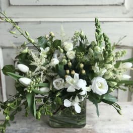 White floral arrangement in a square glass vase