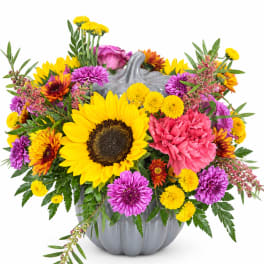 Colorful bouquet in a gray pumpkin vase with a sunflower centerpiece